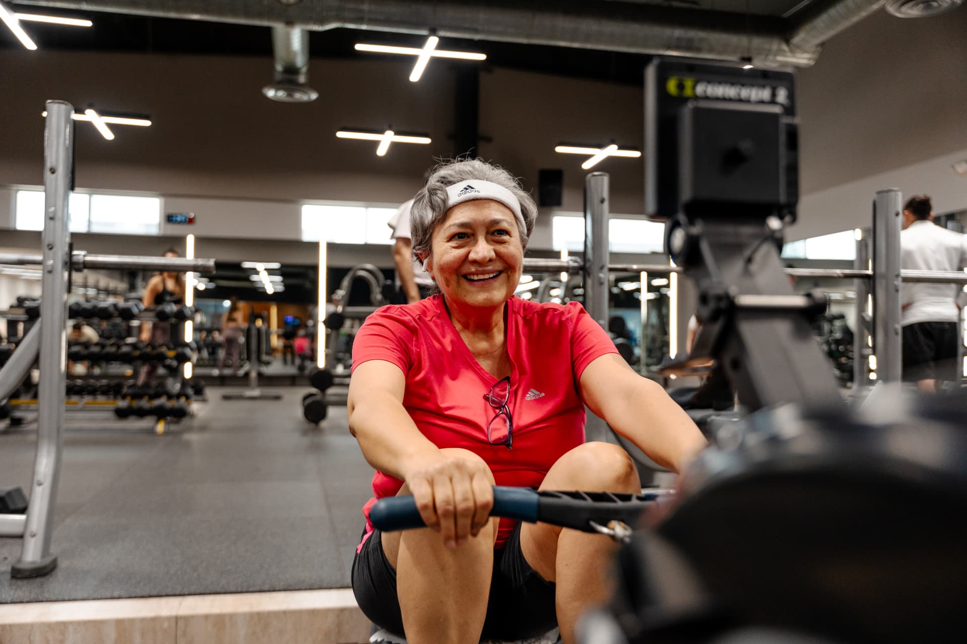 Mujer sonriendo mientras entrena en la remadora